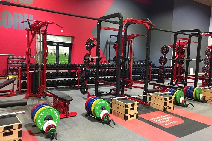 Multiple Power Racks with weights and barbells, front angle