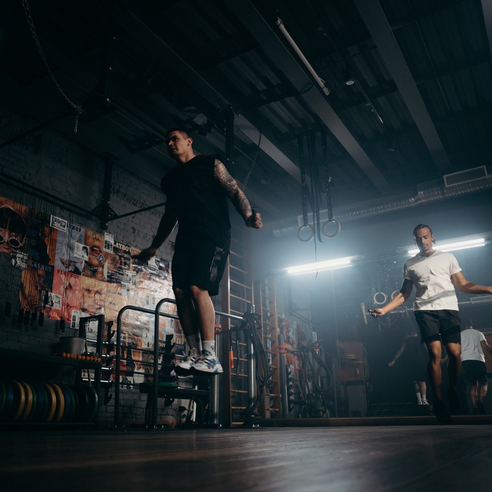 Two men skipping rope in a gym studio