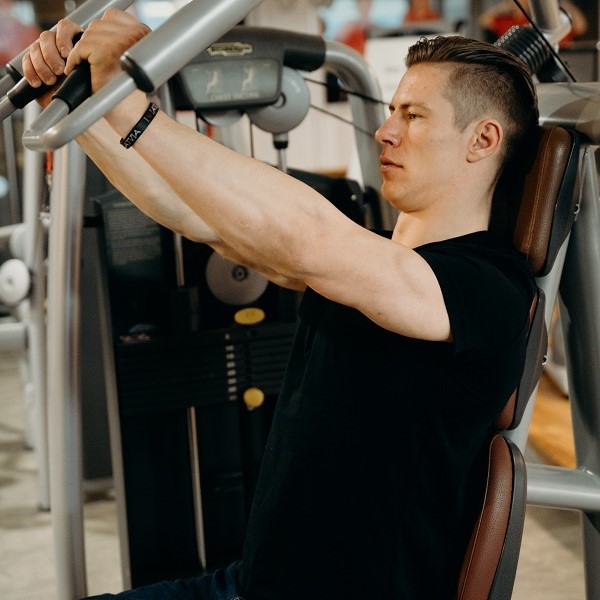 White man using a chest press machine